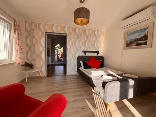 Szoba ággyal és piros fotellel a Fűgeházban