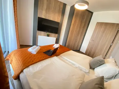 Dandelion Royal Homes hálószoba ágy, narancssárga takaróval és tévével