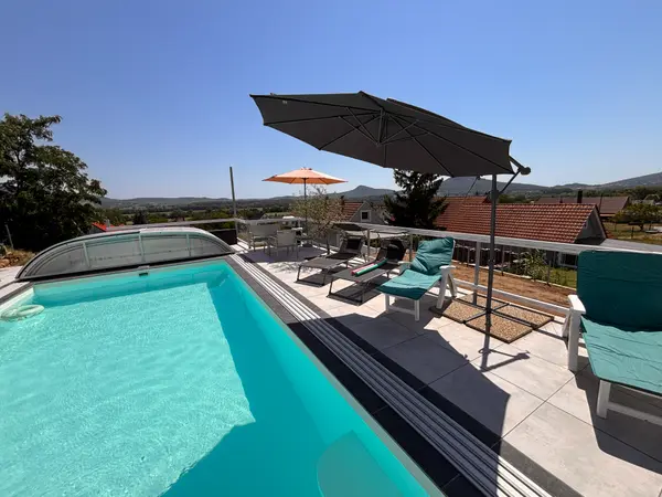 Panorama Pool medence és terasz napernyőkkel a domboldali kilátás felé.