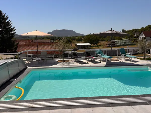 Panorama Pool a dombok felé néző napozóágyakkal és félig nyitott fedéssel.