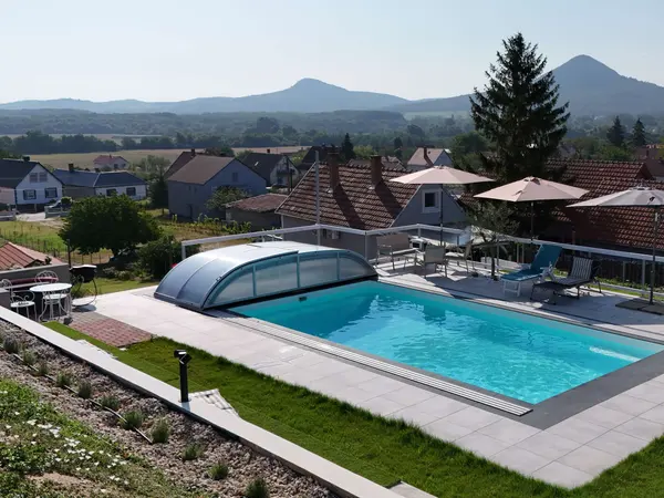 Panorama Pool tágabb nézete medencefedéssel és tanúhegyekkel a háttérben.